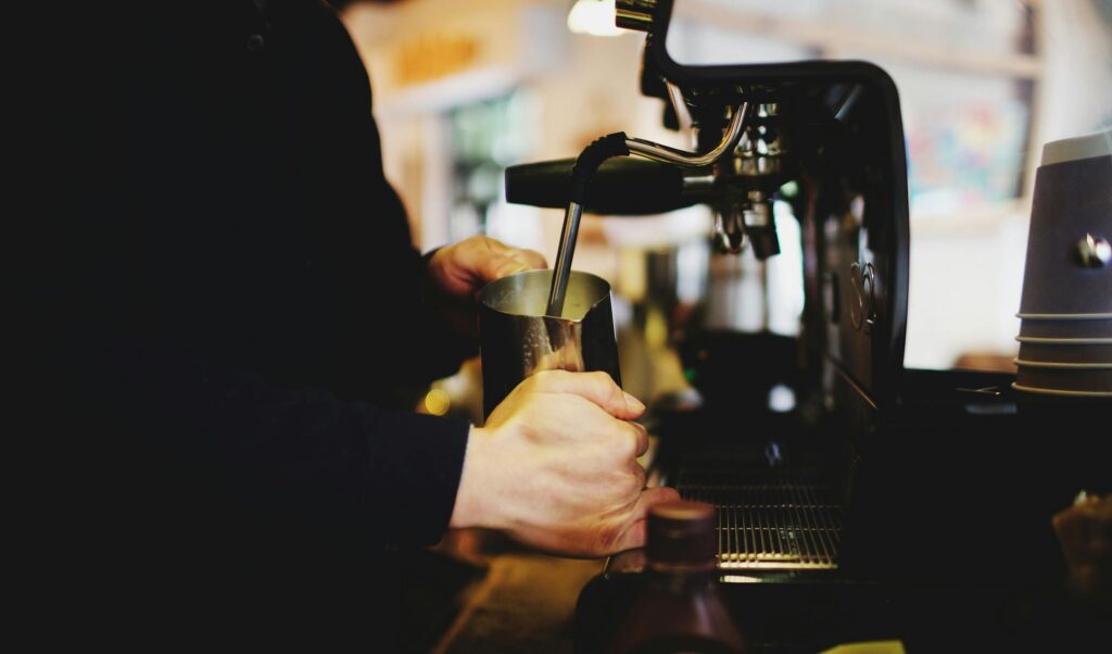 Coffee shop insurance guide: barista pulling an espresso shot behind the counter