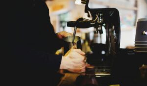 Coffee shop insurance guide: barista pulling an espresso shot behind the counter