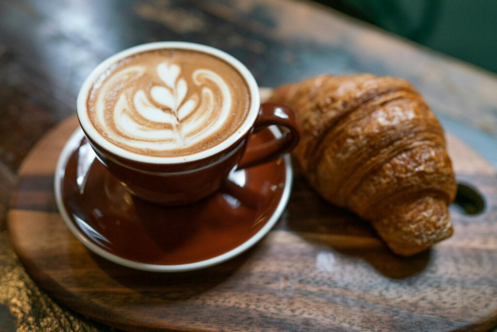 Coffee and a croissant on a cafe table, a guide to the coffee shop business plan