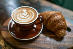 Coffee and a croissant on a cafe table, a guide to the coffee shop business plan