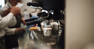 Barista making coffee at a cafe counter