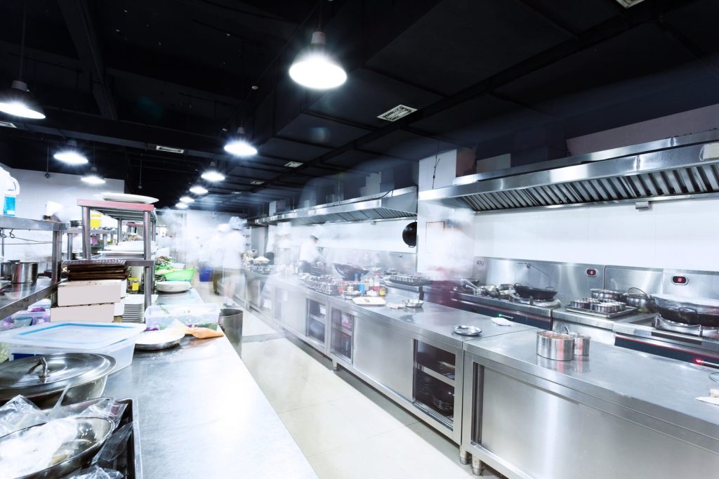 How much does a commissary kitchen cost: a busy shared commercial kitchen with stainless prep lines