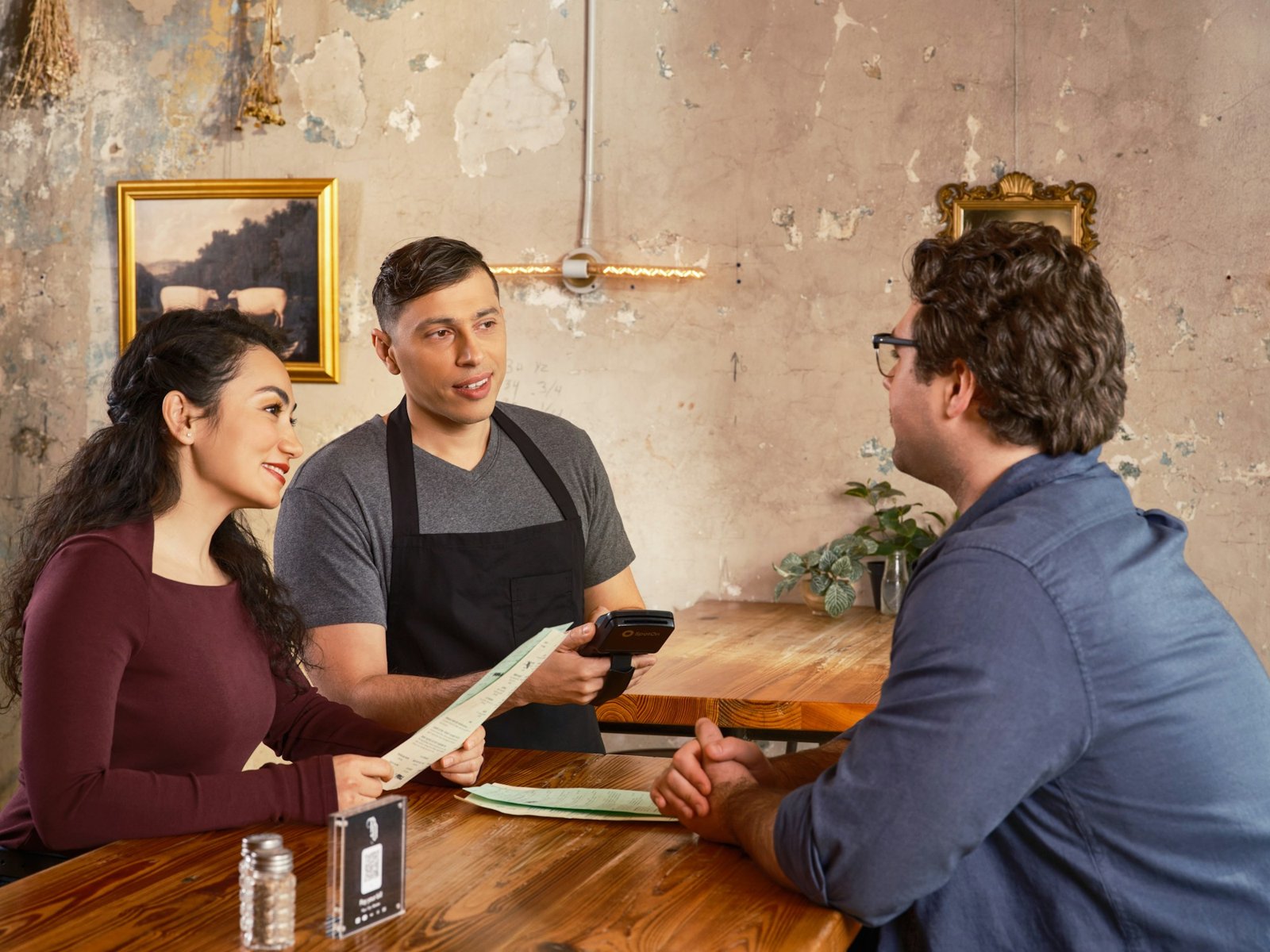 Server taking an order from guests at a restaurant soft opening