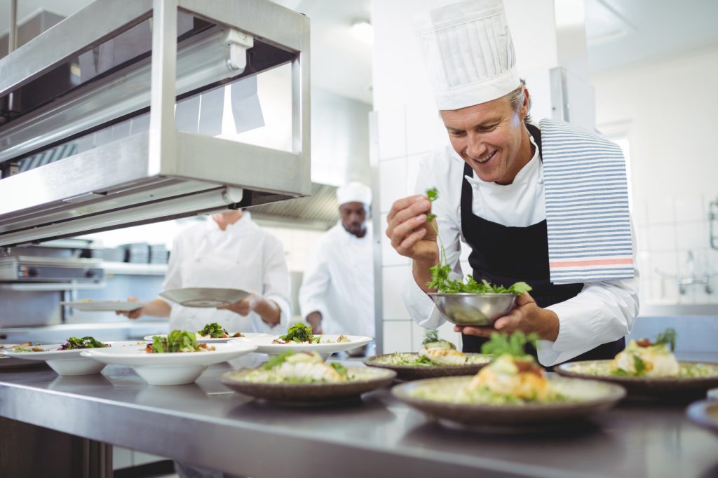 How to open a restaurant with no experience: a chef plating dishes at the pass