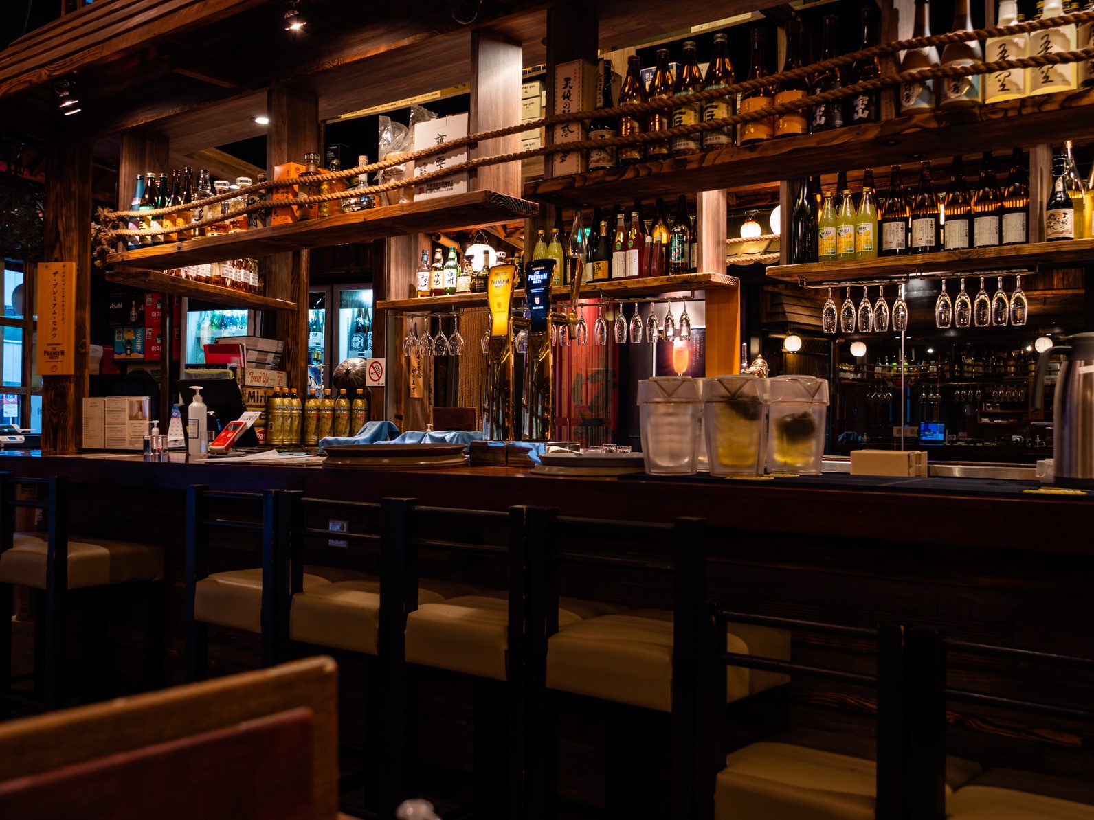Small bar counter with stools and back bar shelves, the kind of space you plan when you open a small bar